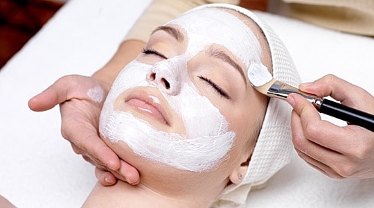 Woman receiving a facial treatment in spa setting