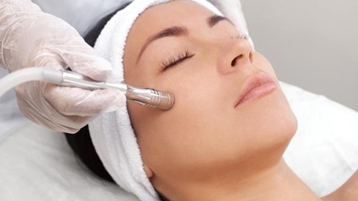 Facial treatment in progress with skincare device.