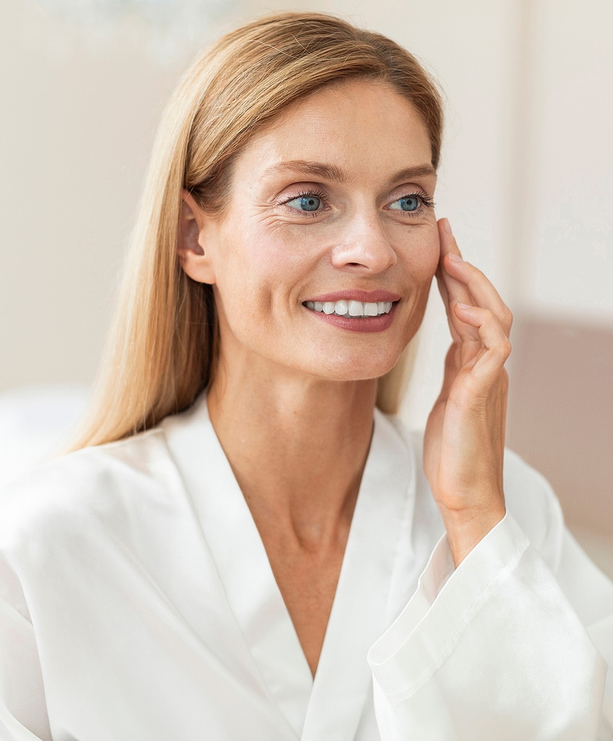 Roswell Sculptra model in robe applying skincare product on face.