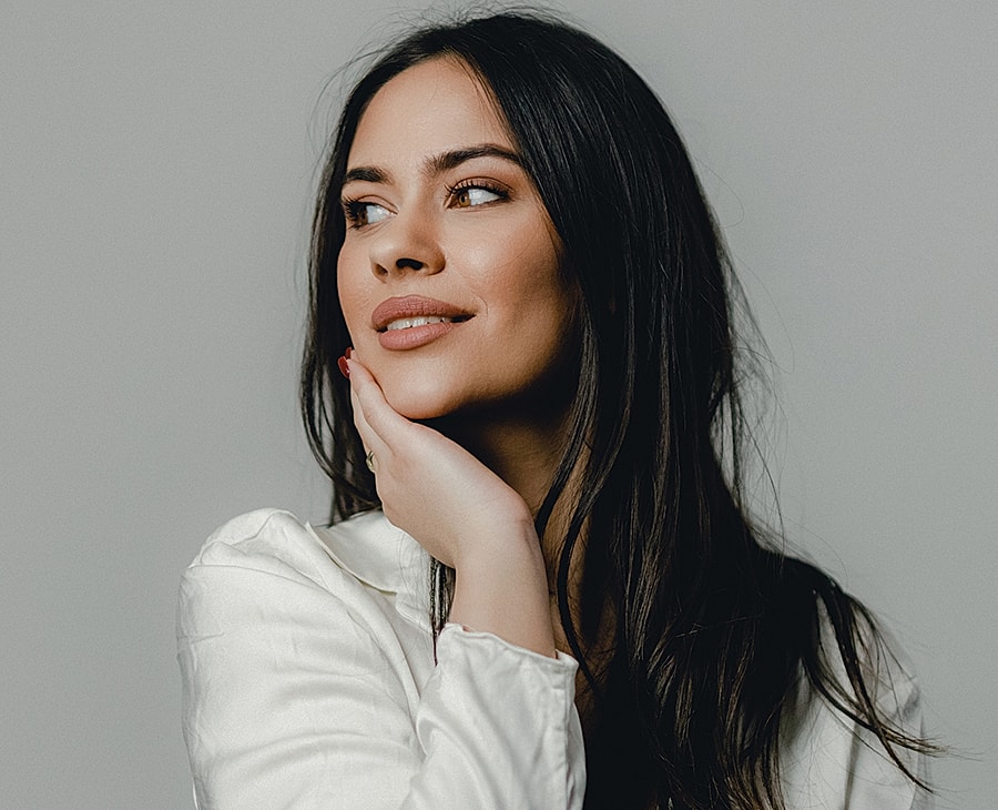Woman with long hair in thoughtful pose.