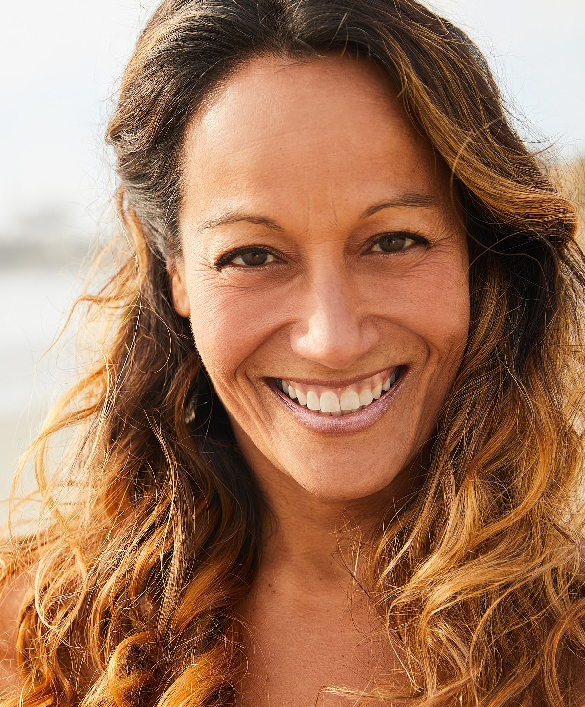 Roswell NAD+ Injections model with long, wavy hair outdoors.