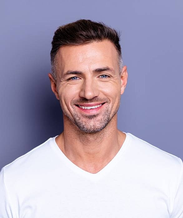 Roswell Men's services model in a white t-shirt against purple background.