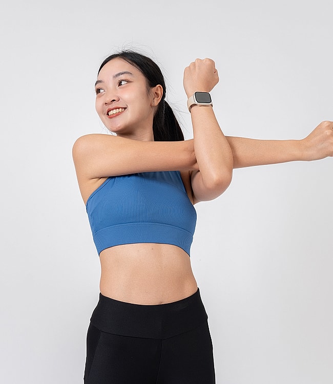 Roswell Wellness Shots model stretching in athletic wear, smiling.